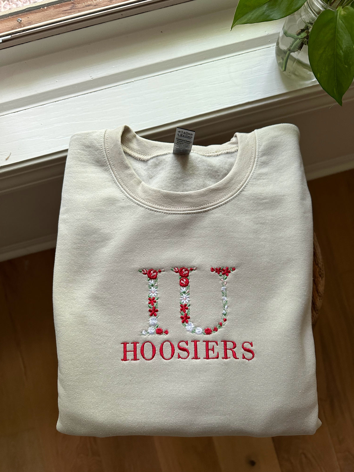 Ivory embroidered IU Hoosiers sweatshirt with red, green, and white floral detailing